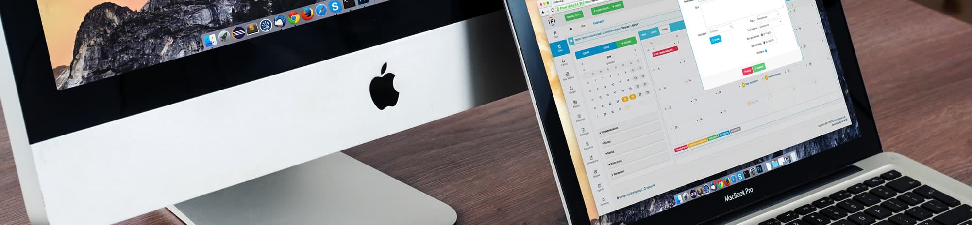 An iMac and a MacBook Pro on a desk showing accounting software